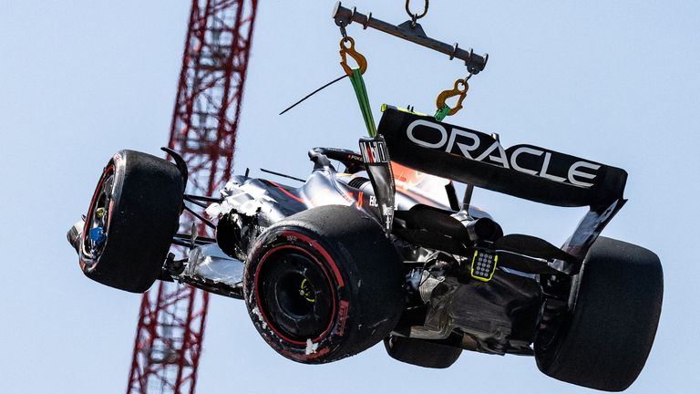 Perez's damaged Red Bull is lifted off the track