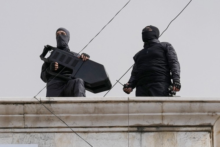 Hezbollah fighters stand guard on a building roof top to protect their supporters during a pro-Palestinian protest in Beirut.