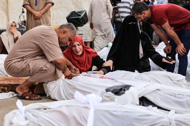 People mourn the dead outside Al-Aqsa hospital in Deir al-Balah, Gaza.