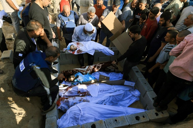 Mourners gather with Wael Dahdouh, Gaza bureau chief for Al Jazeera Arabic, during the burial of his wife, son, daughter and grandson in Gaza.