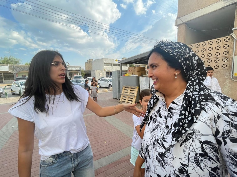 Yael Shushan, right, celebrates the return of Ori Megidish with another neighbor today.