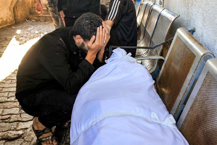 A man cries over the body of victim of the explosion at al-Ahli hospital in Gaza on Oct. 18, 2023.