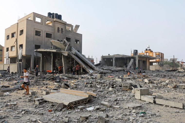 Palestinians inspect the site of Israeli strikes on a house in Khan Younis in the southern Gaza Strip, October 23, 2023. 