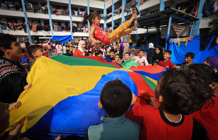 Palestinian children who have fled their homes play with the help of games organzsed by humanitarian workers as they shelter at a United Nations-run school in Khan Younis in the southern Gaza Strip on Oct. 23, 2023.