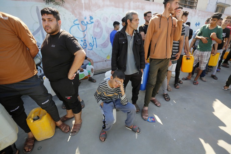 People line up in front of a gas station to get fuel in Deir al-Balah, Gaza, on Oct. 19, 2023. 