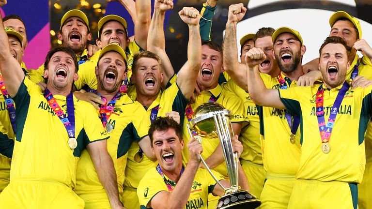 Pat Cummins lifts the Cricket World Cup trophy aloft as Australia celebrate their six-wicket win over India in the final