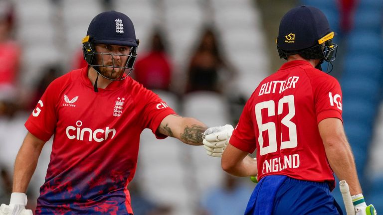 England's Phil Salt..celebrates with captain Jos Buttler after scoring fifty runs during the bowling of West Indies' Andre Russell, left, during the fourth T20 cricket match at Brian Lara Stadium in Tarouba, Trinidad and Tobago, Tuesday, Dec. 19, 2023. (AP Photo/Ricardo Mazalan)