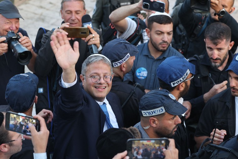 Israel's National Security Minister Itamar Ben-Gvir, flanked by Israeli police officers, greets people gathered in front of Damascus Gate leading to the Old City of Jerusalem, during the annual 'flags march' to mark "Jerusalem Day", on May 18, 2023.