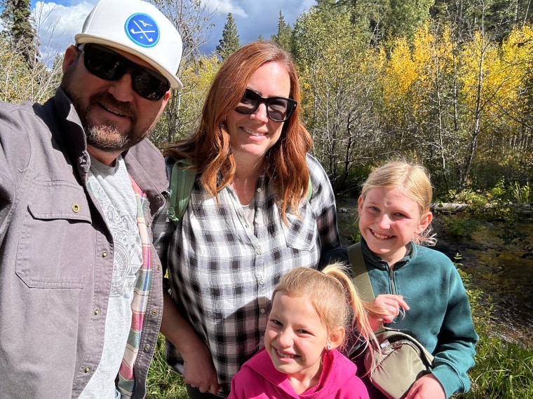 Two parents and two children on a hike. 