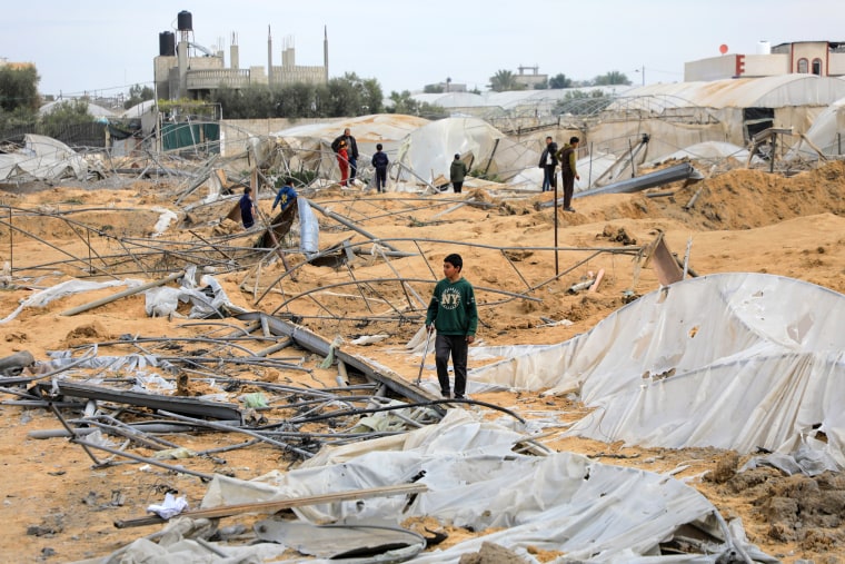 Palestinians check the damage after Israeli air strikes