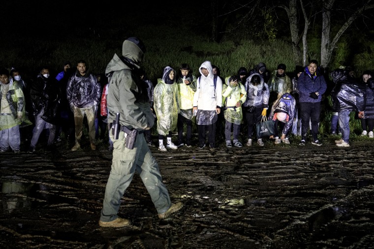 Immigrants wait to be transported by U.S. Border Patrol agents.