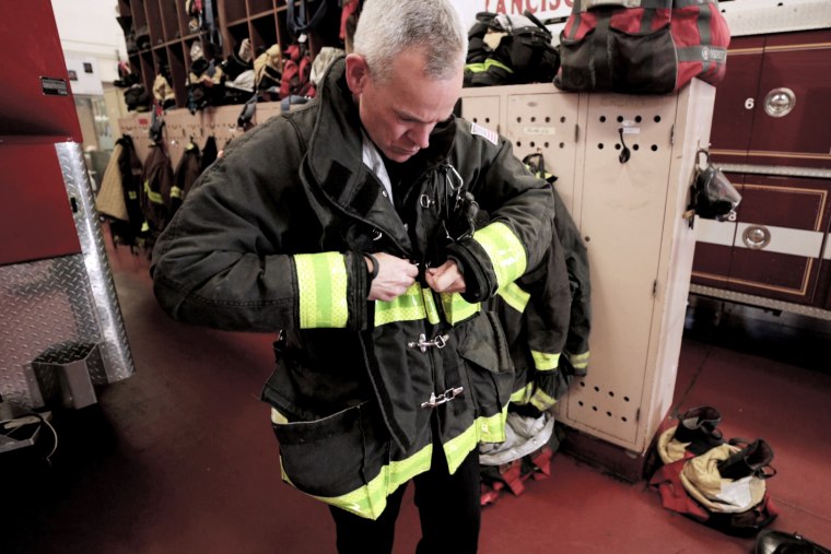 Adam Wood buckles his coat as he puts on his uniform